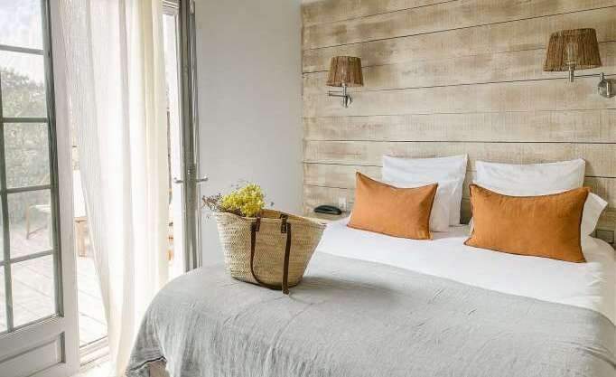 Sac sur le lit d'une chambre de l'hôtel Les Arnelles, Hôtel 4 étoiles avec Piscine en Camargue